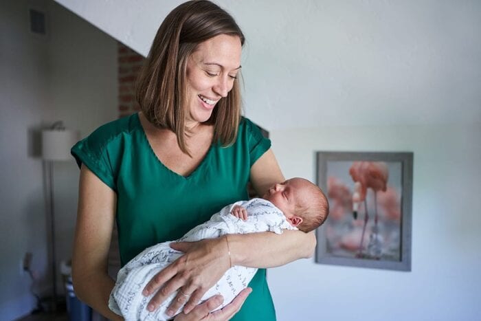 mother looking at newborn son in nursery for lifestyle newborn photo session