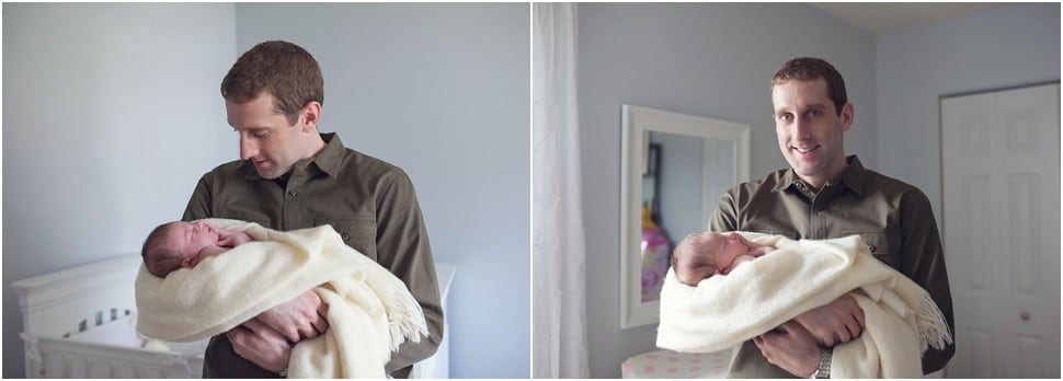 dad holding sleeping baby swaddled in a fuzzy blanket looking at baby by the window with natural light best newborn pictures in pittsburgh 