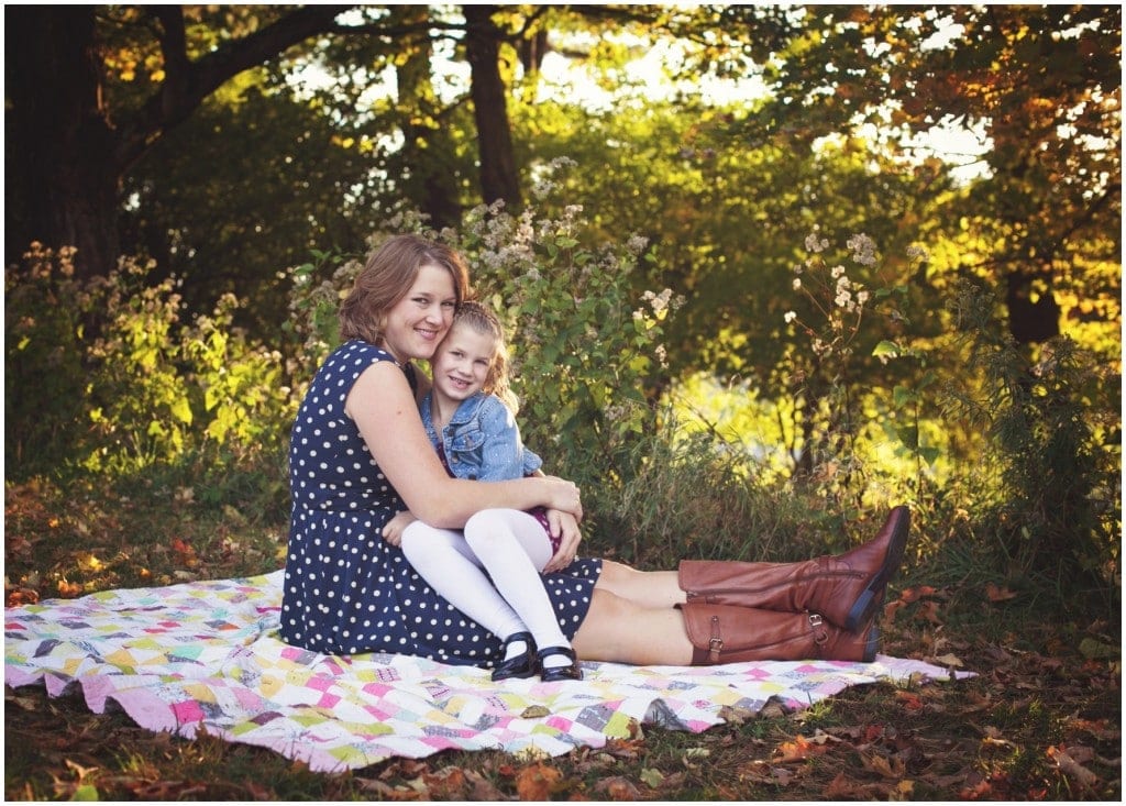 mother and daughter sitting on a blanket and snuggling for a photo session  Boardman family photographer 