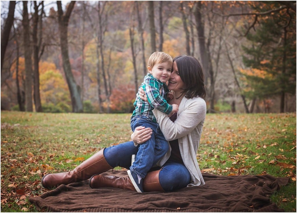 mother with son head to head on a blanket at Townsend park in murrysville with fall leaves and foliage in the background