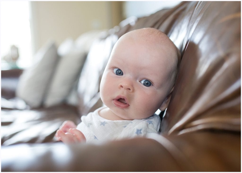 baby on couch looking at camera wide blue eyes pittsburgh baby photographer