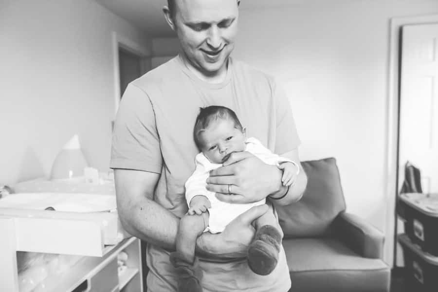 newborn baby in dads hands in pittsburgh nursery black and white