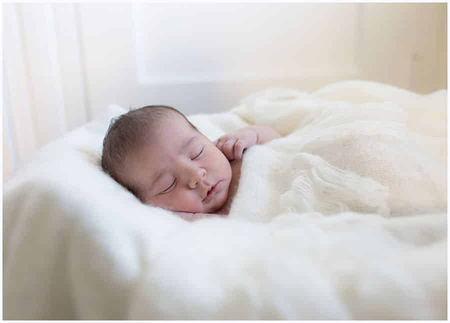 newborn baby swaddled in white fluffy blanket