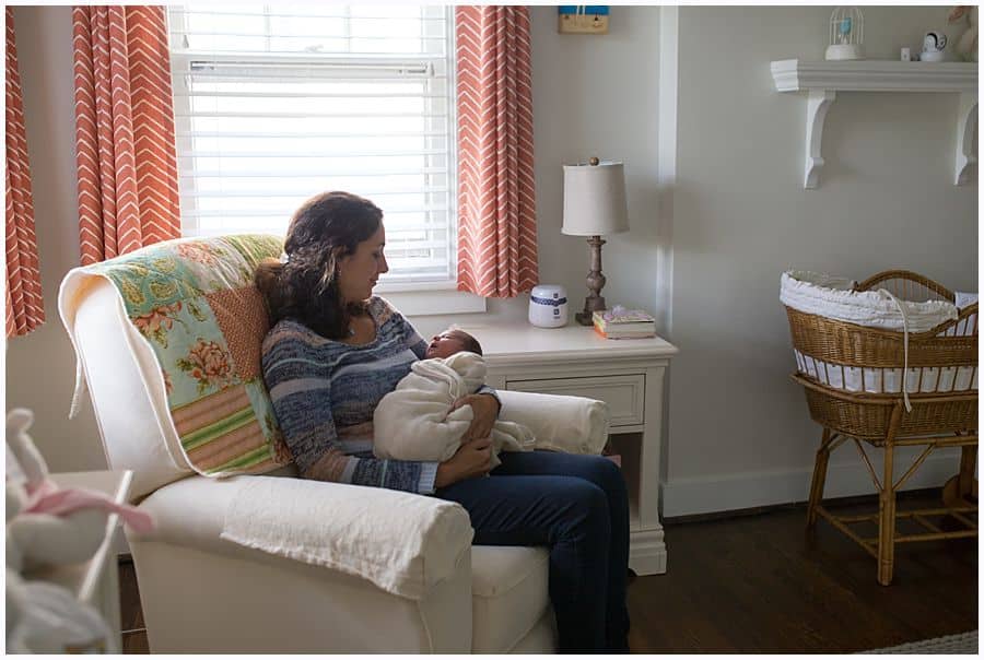 squirrel hill photographer mom in nursery with newborn in glider at home