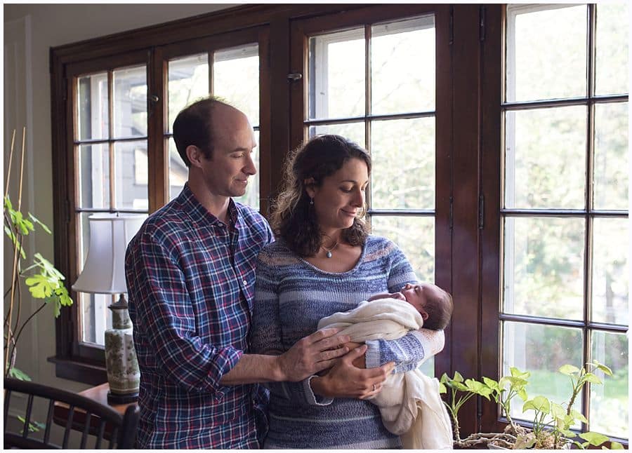 mom and dad in window light with newborn in squirrel hill house