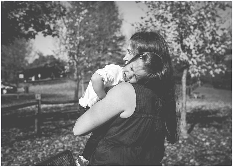 daughter crying in moms arms at park in black and white 