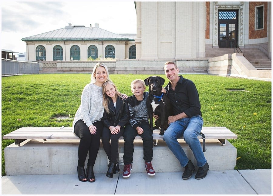 family with dog on a bench outside for a family photo session 