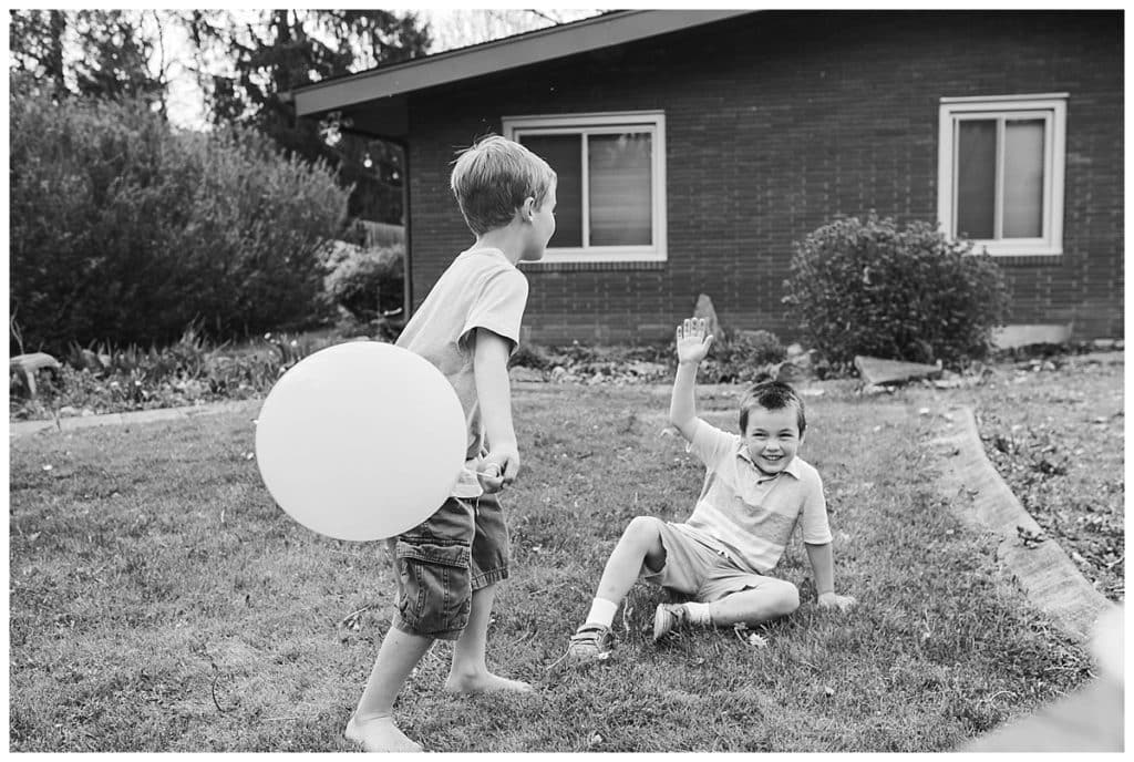 black and white photo of toddler boys and balloon