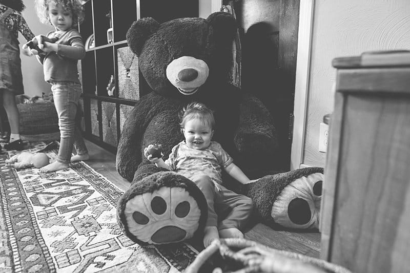 little boy on a big teddy bear at home for a lifestyle photo session
