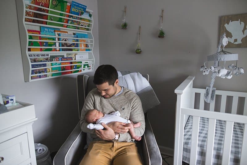 dad holding newborn baby in nursery at home in pittsburgh