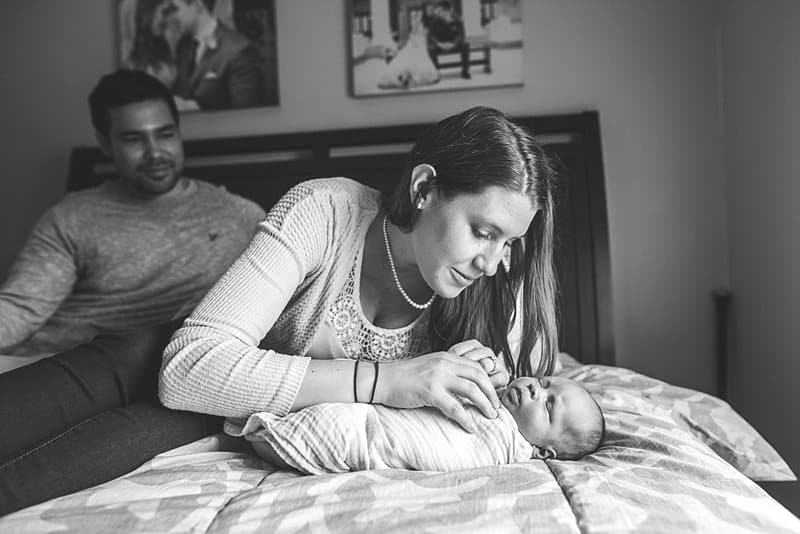 mom and newborn on bed in pittsburgh home for lifestyle session