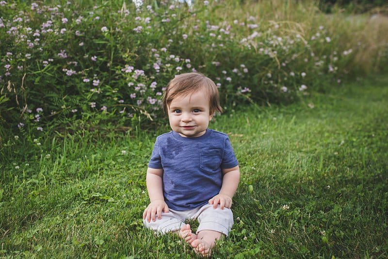 baby boy son in a pittsburgh field of wildflowers at sunset