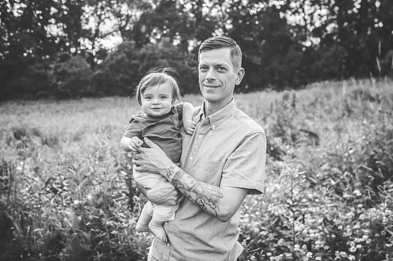 father holding son in a pittsburgh field of wildflowers at sunset