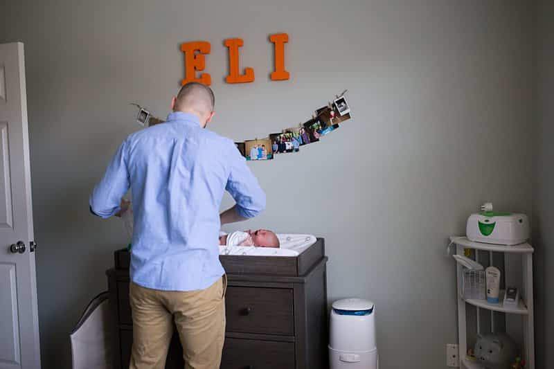 newborn baby on changing table with dad lifestyle photo session 