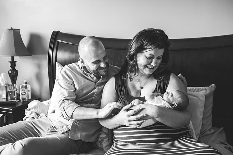 pittsburgh newborn session home un posed mom and dad on bed