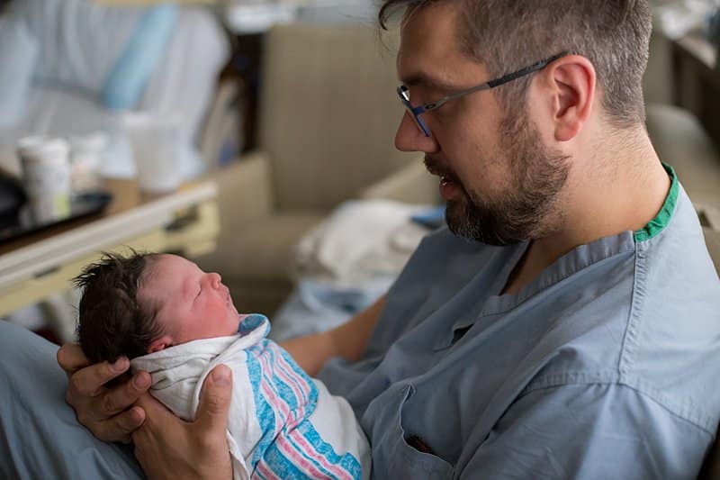 newborn with dad in hospital bed birth session in pittsburgh