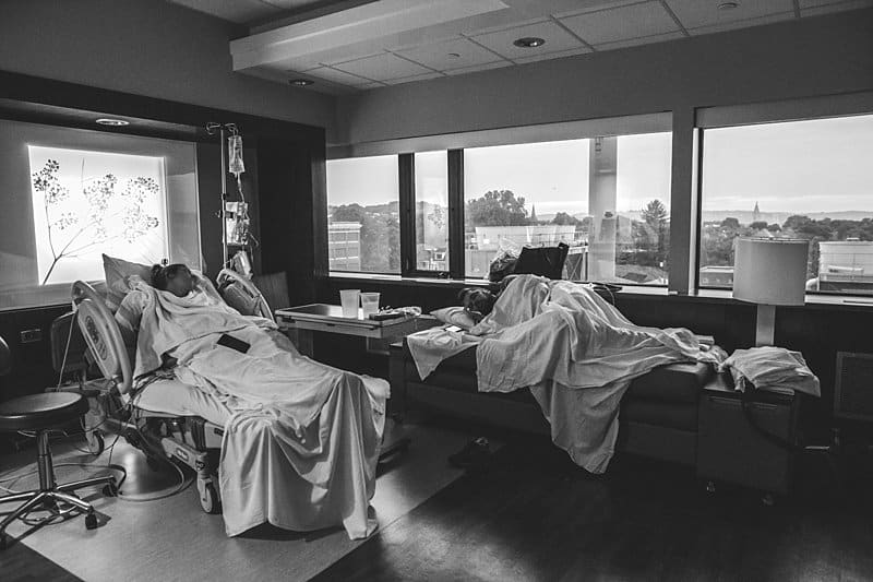dad supporting mom in hospital bed birth session in pittsburgh