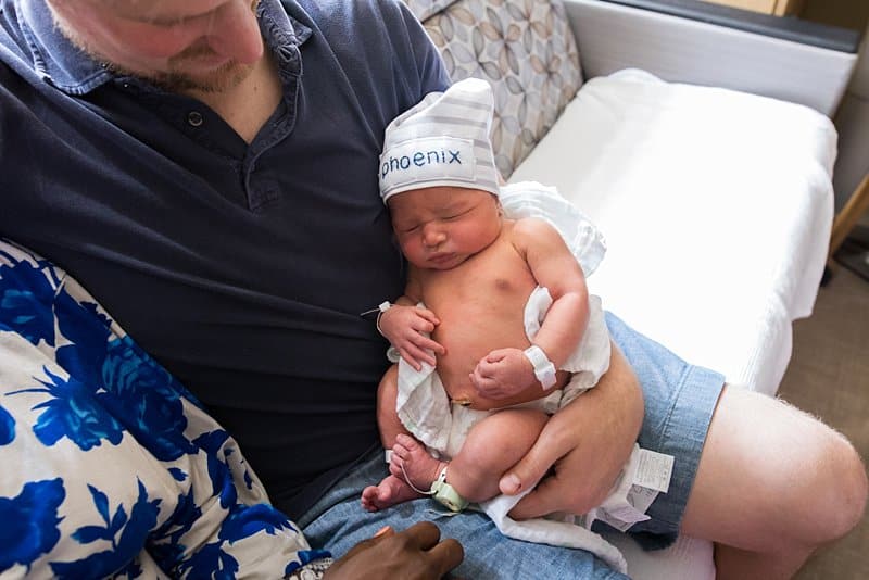 dad holding newborn at magee hospital fresh 48 session