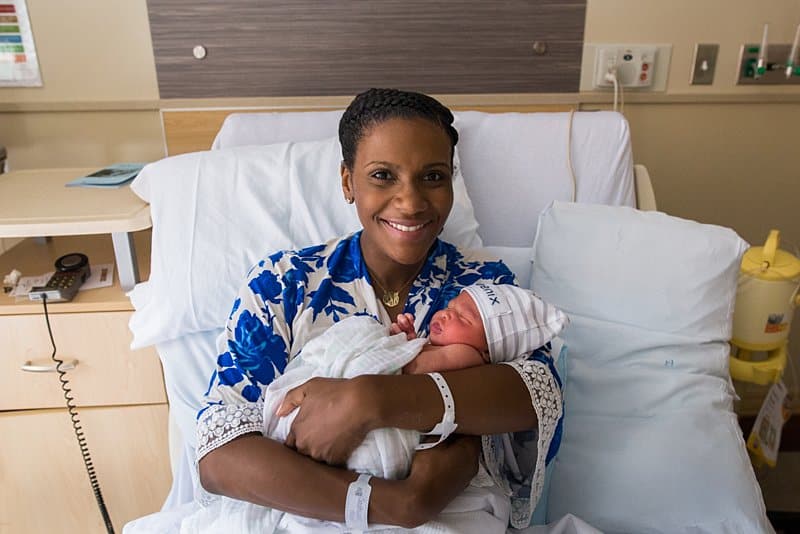mom at magee hospital holding newborn baby in bed