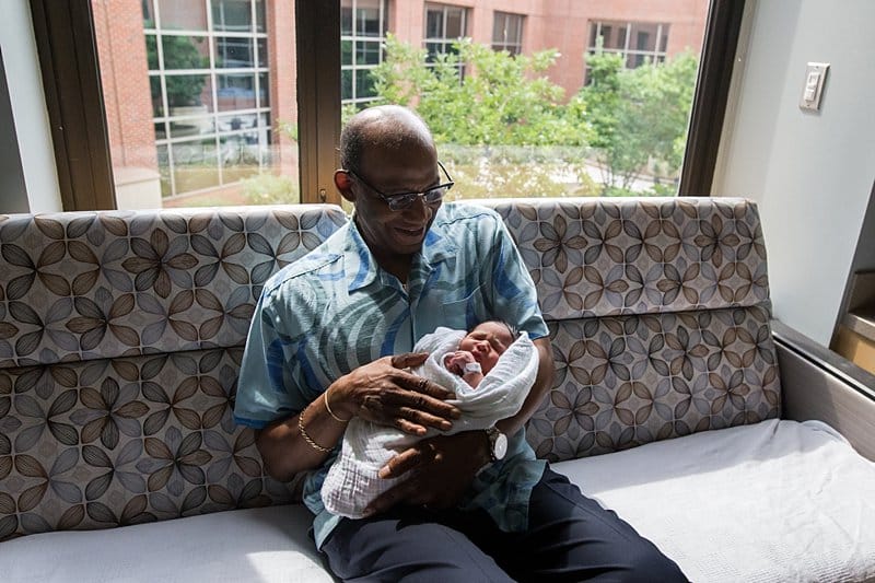 grandfather holding newborn at magee hospital fresh 48 session