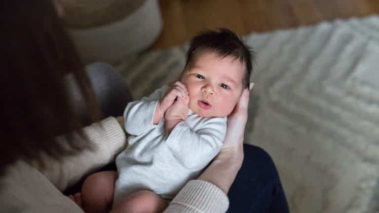 newborn baby in moms arms for pittsburgh newborn photo session how to find a newborn photographer