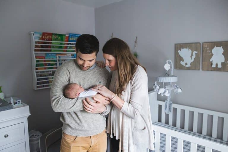 mom and dad holding newborn in nursery in pittsburgh home