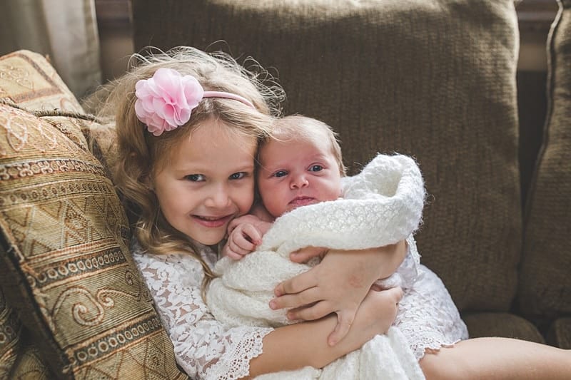 big sister holding baby sister