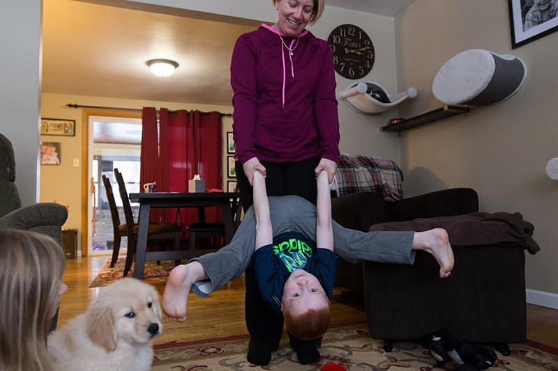 mom holding boy upside down in living room