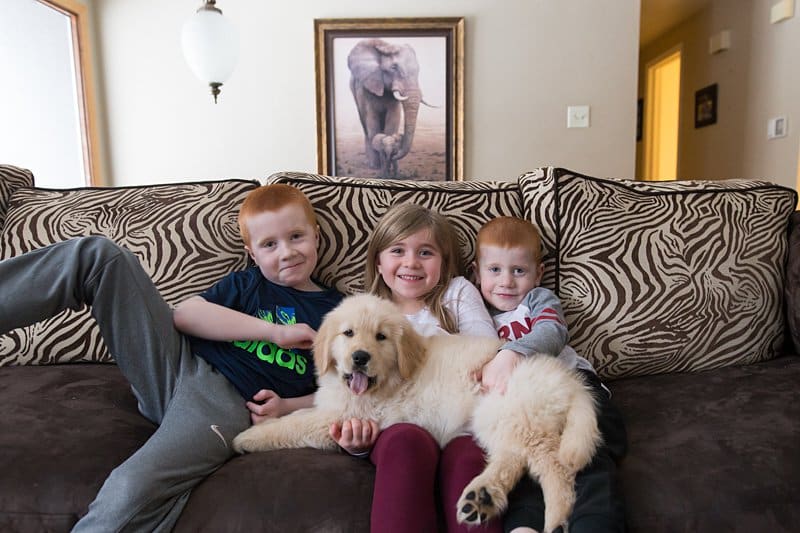 three kids and a puppy on couch
