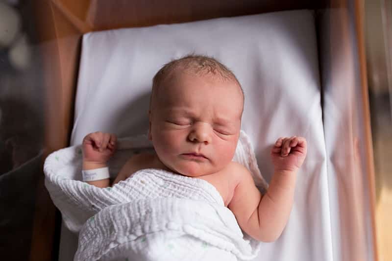 newborn baby on hospital bassinett