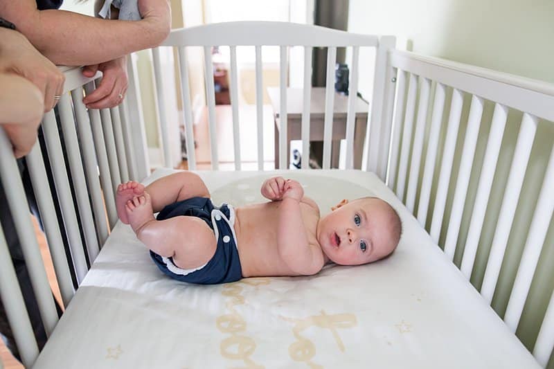 baby boy in white crib in cloth diaper in pittsburgh nursery 