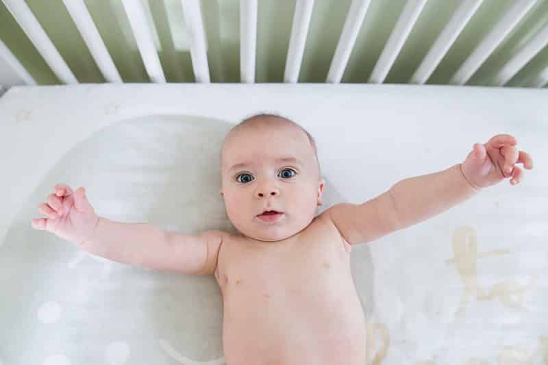 baby boy in white crib in pittsburgh nursery 