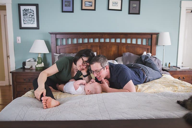 mom dad and baby boy on bed in pittsburgh home