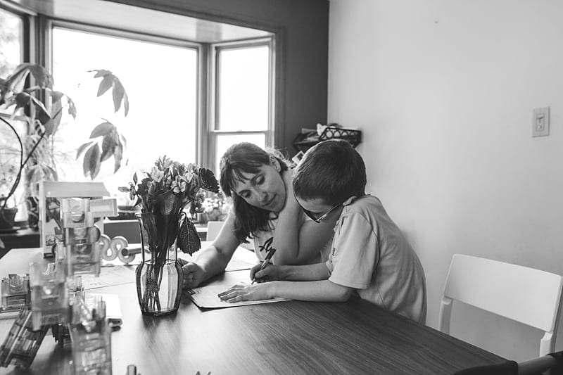 mom working on homework with son in kitchen