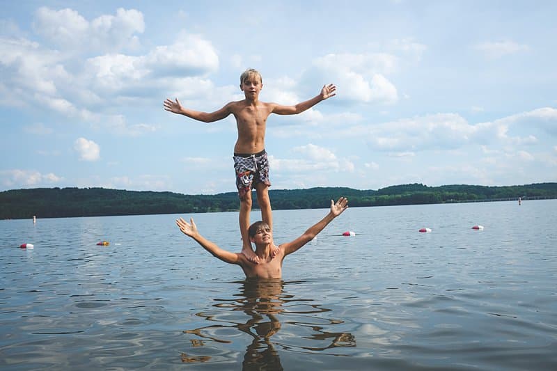 boy standing on brothers shoulders in lake aurthur moraine state park