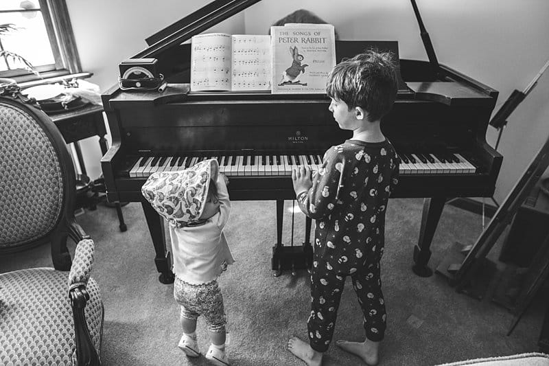 brother and baby sister playing piano in pittsburgh home