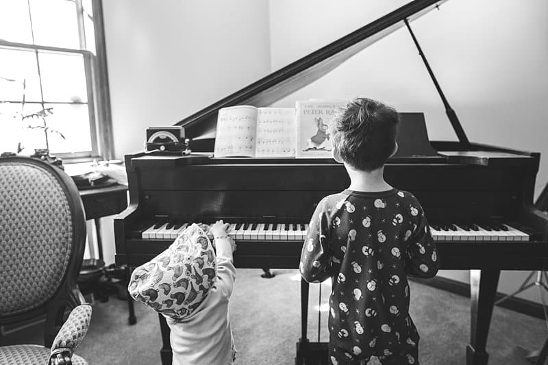 brother and baby sister playing piano in allison park home
