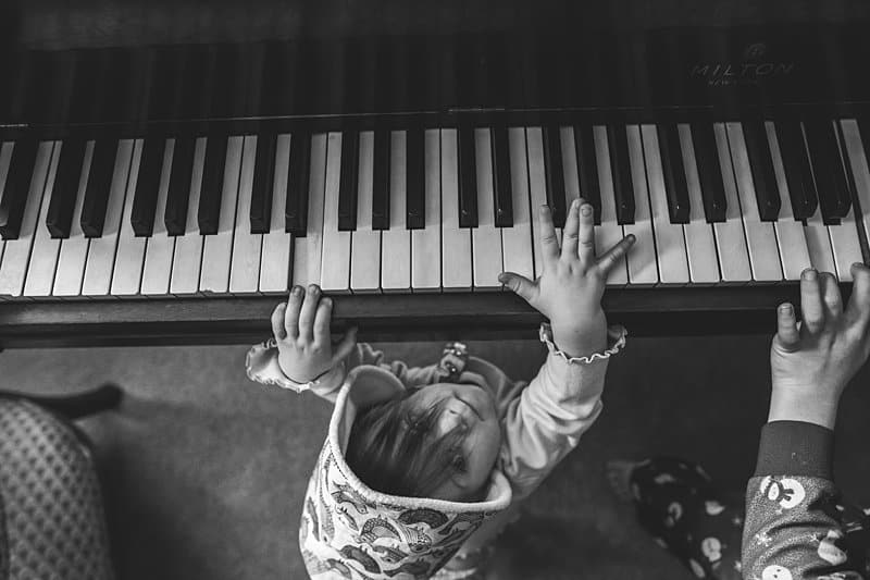 brother and baby sister playing piano in allison park home