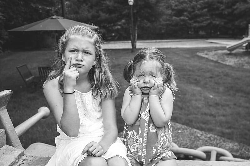 sister making silly faces in sewickley riverfront park