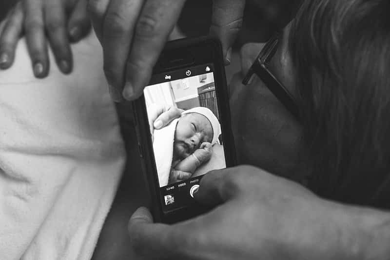 photo of a cell phone photographing newborn