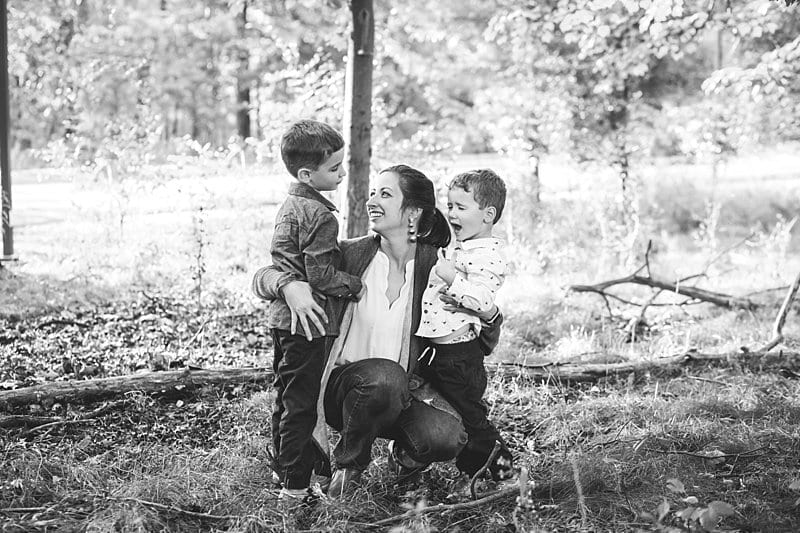 mom smiling and kneeling down with two sons