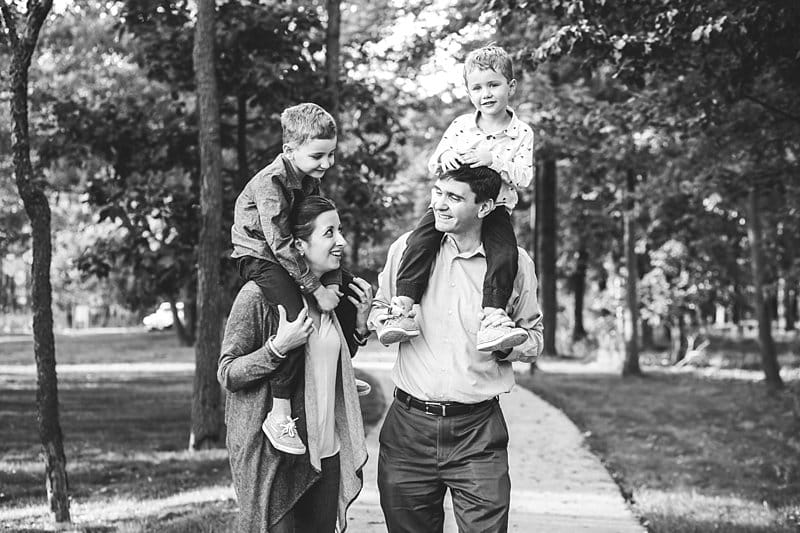 parents with children on shoulders walking in cranberry park