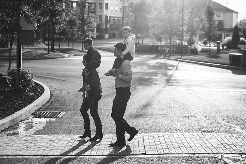 parents with children on shoulders crossing street in cranberry park