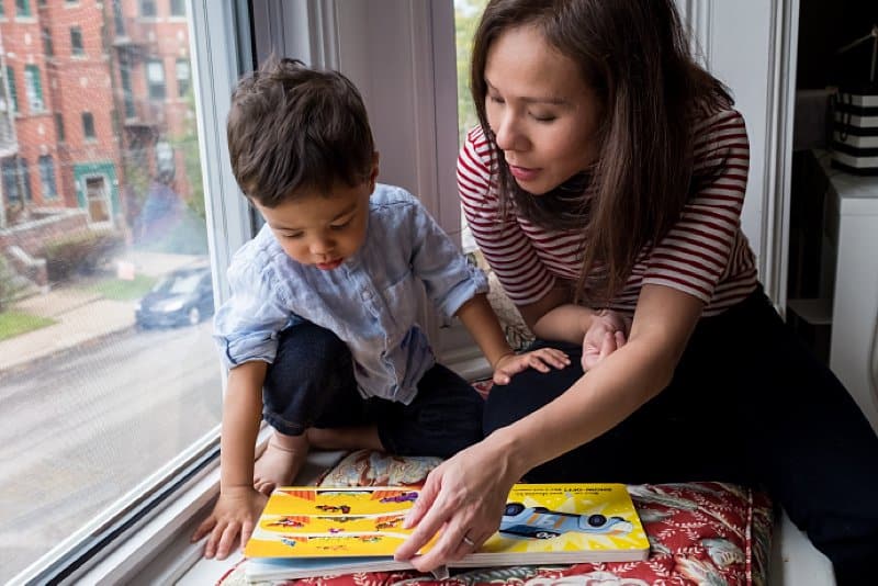 mother and son reading a book in window seat of shadyside home