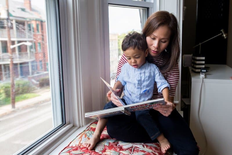 mother and son reading a book in window seat of pittsburgh home
