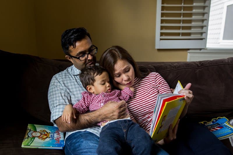 parents reading to boy on couch