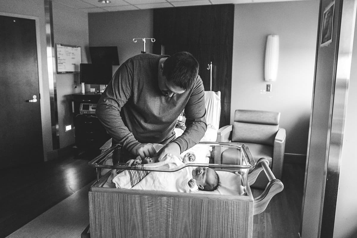 dad changing newborn baby in pittsburgh hospital bassinet
