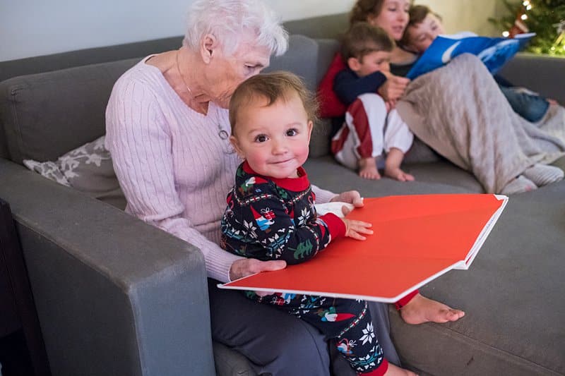 great grandma holding and reading to toddler