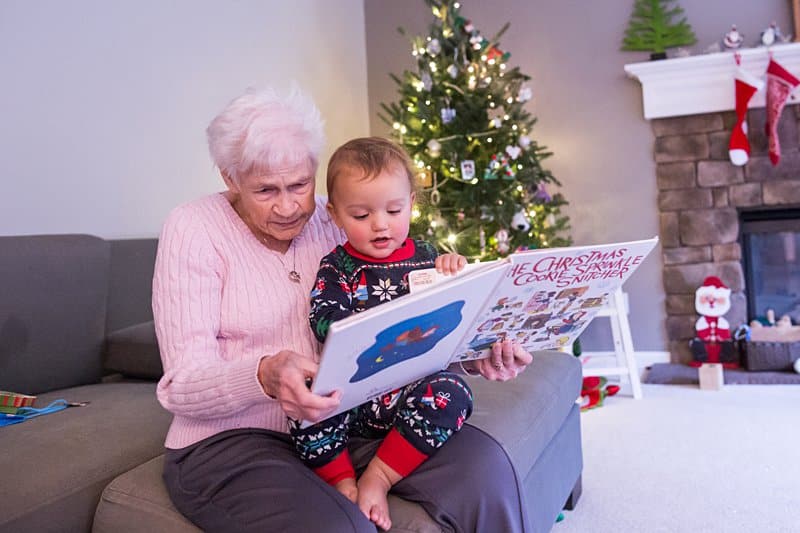 great grandma holding and reading to toddler
