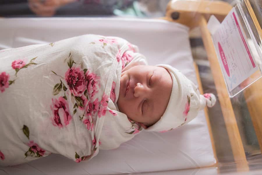 newborn baby in basinet at hospital for a fresh 48 session swaddled in rose wrap
